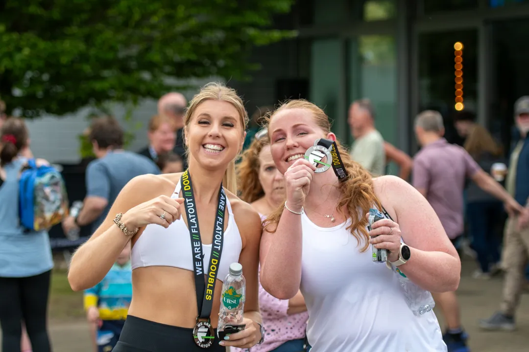 Two participants celebrating with their FLATOUT Doubles medals